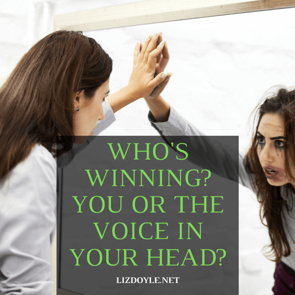 Image of a woman staring at herself in the mirror with text - "Who's Winning? You or the Voice in Your Head? lizdoyle.net"